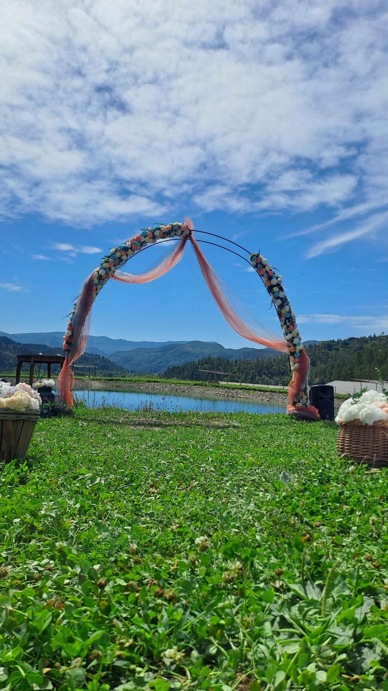Arche de cérémonie fleurie avec voilage pêche, en extérieur