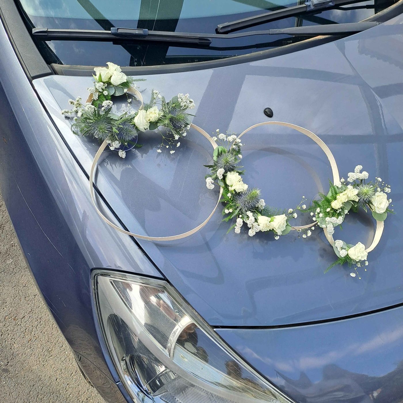 Cerceaux fleuris décorant le capot d'une voiture de mariage